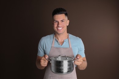 Photo of Happy man with pot on brown background