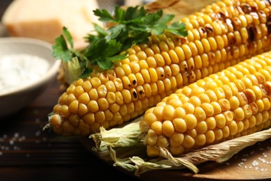 Delicious grilled sweet corn cobs on board, closeup