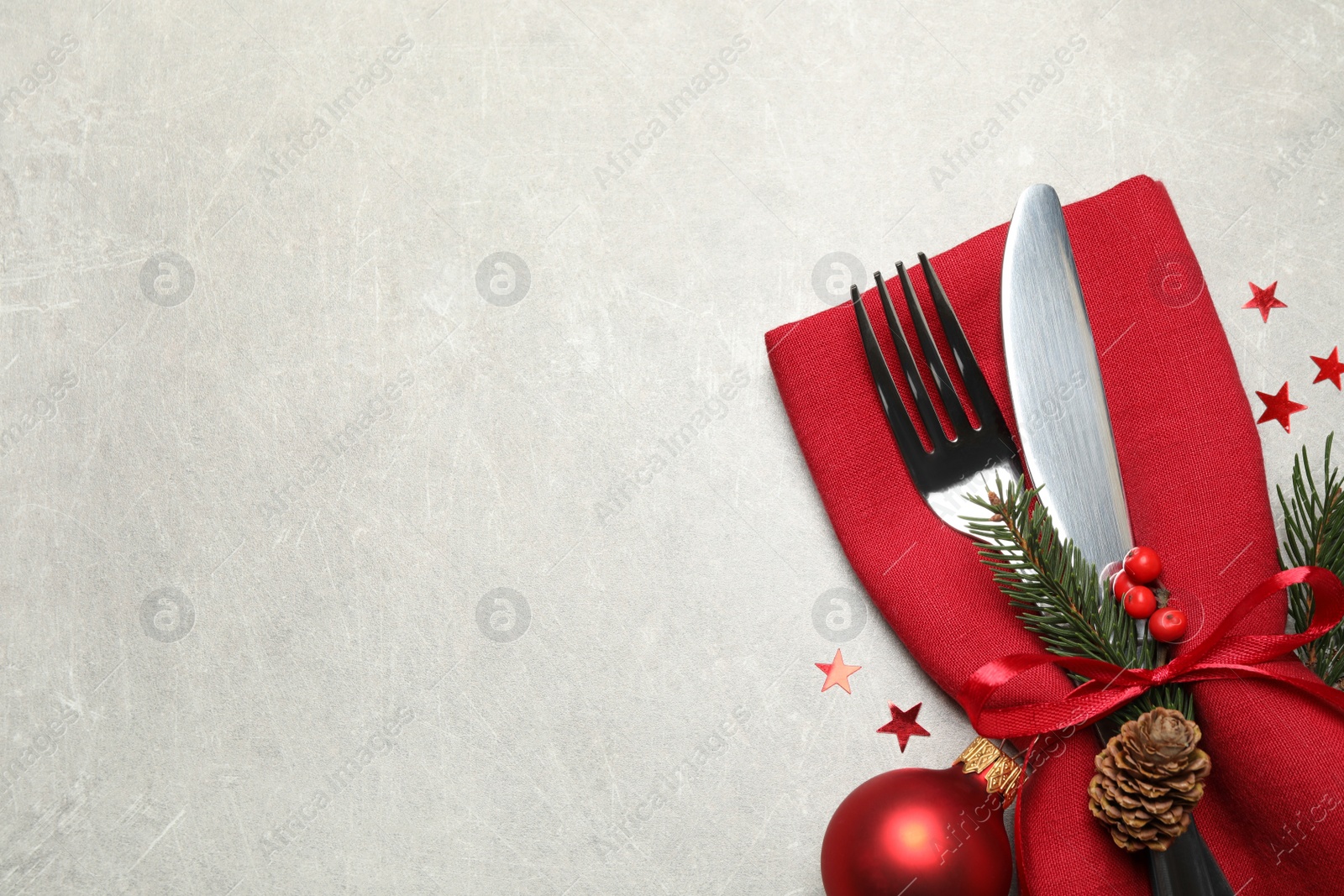 Photo of Cutlery set and Christmas decor on light grey table, flat lay. Space for text