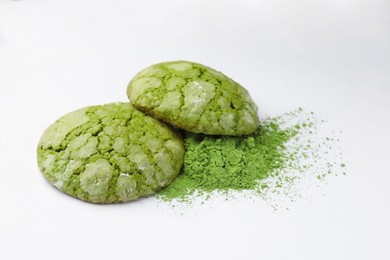 Tasty matcha cookies and powder on white background