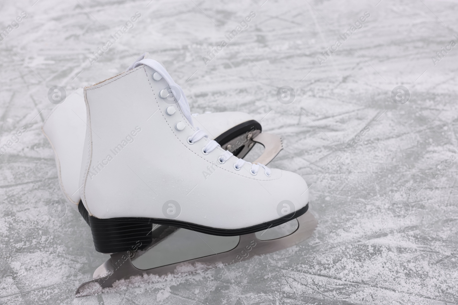 Photo of Pair of figure skates on ice, space for text