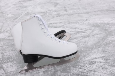 Pair of figure skates on ice, space for text