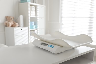 Photo of Modern digital baby scales on table in clinic