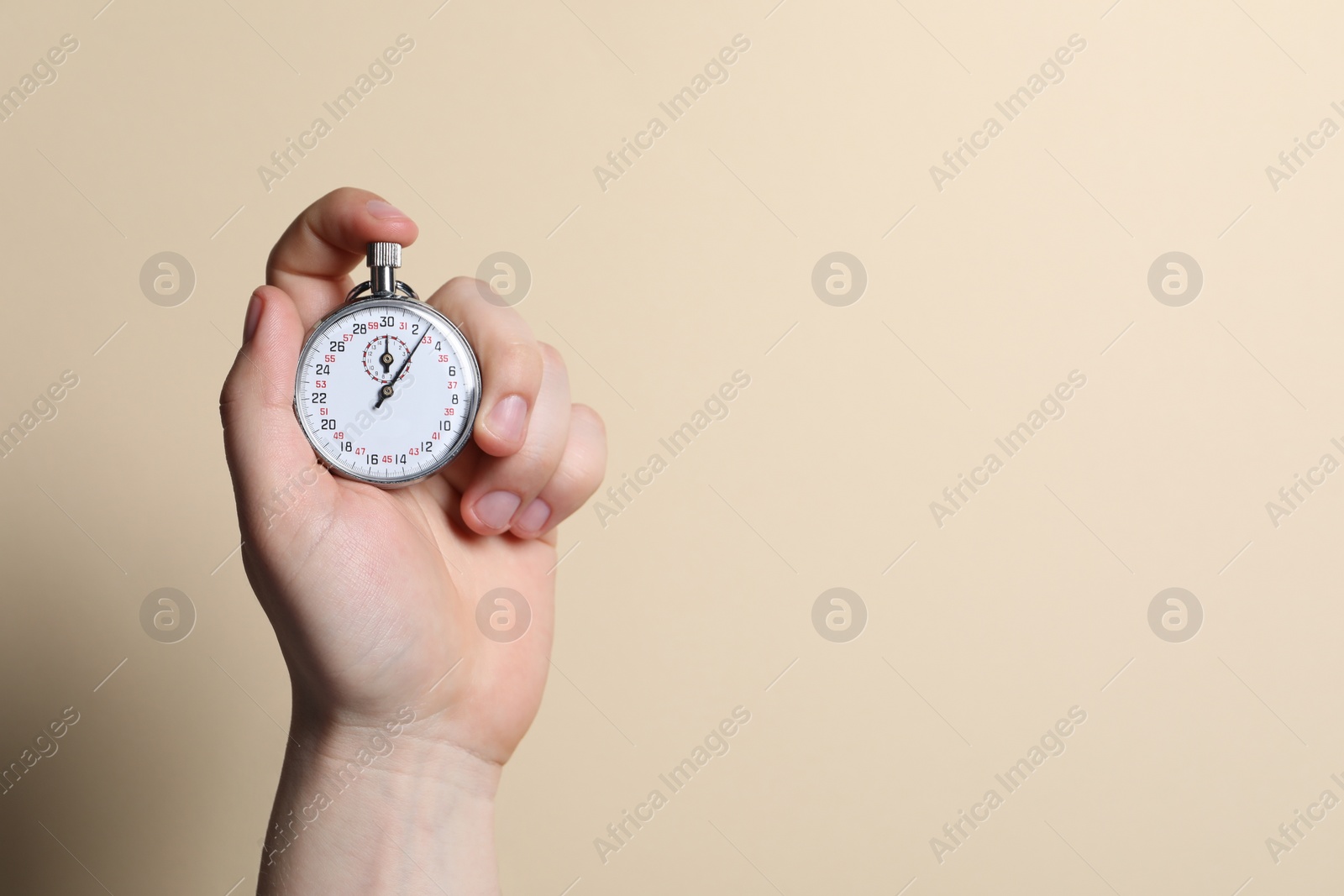 Photo of Man holding vintage timer on beige background, closeup. Space for text