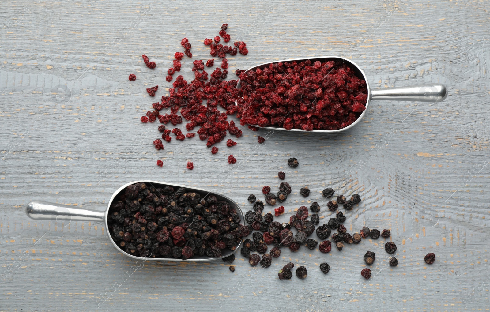 Photo of Dried red and black currants on grey wooden table, flat lay