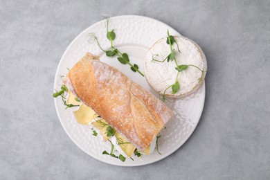 Tasty sandwich with brie cheese on light grey table, top view