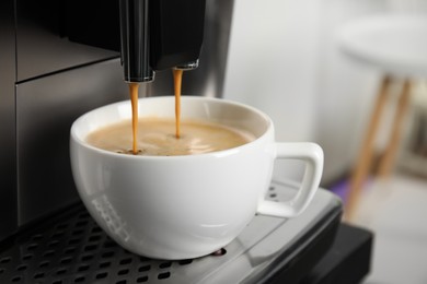 Photo of Espresso machine pouring coffee into cup against blurred background, closeup