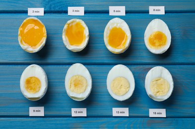 Photo of Different cooking time and readiness stages of boiled chicken eggs on blue wooden table, flat lay