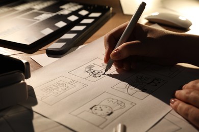 Photo of Woman drawing cartoon sketches at workplace, closeup. Pre-production process