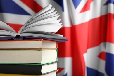 Photo of Learning foreign language. Different books against flag of United Kingdom, space for text