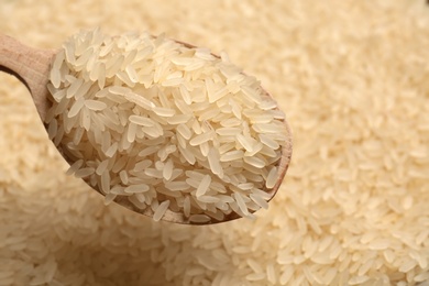 Photo of Parboiled rice in wooden spoon, closeup view