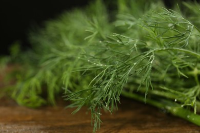 Photo of Fresh green dill with water drops on table, closeup