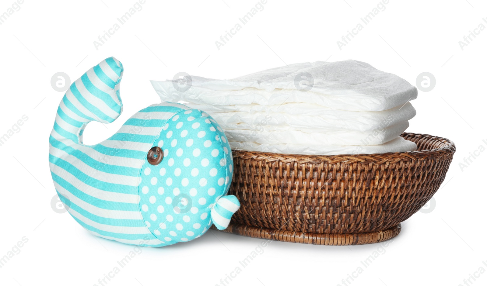 Photo of Wicker bowl with disposable diapers and toy on white background