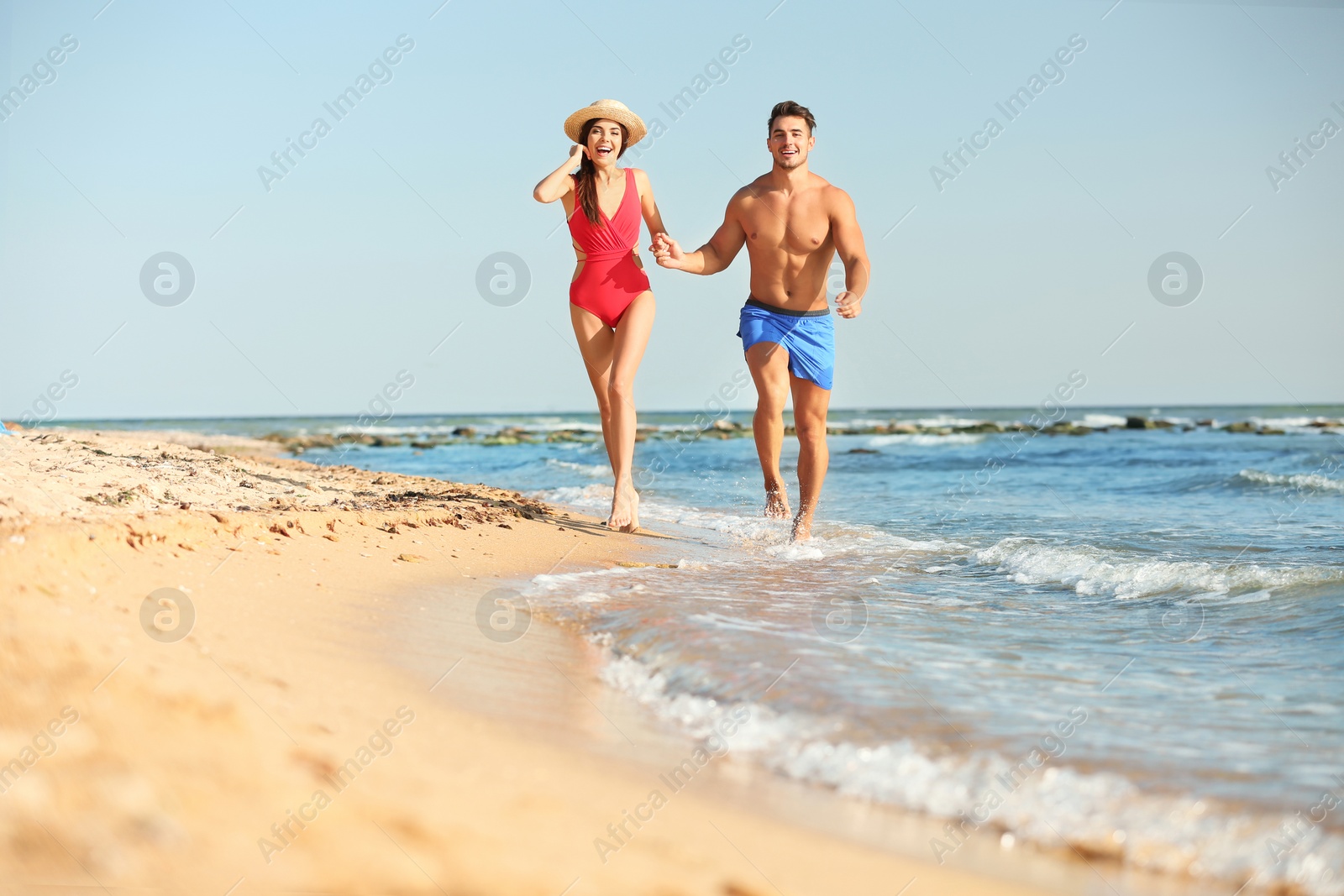 Photo of Happy young couple having fun at beach on sunny day