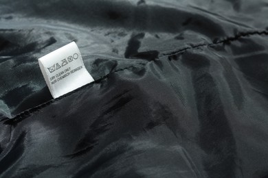 Photo of Clothing label on black garment, space for text