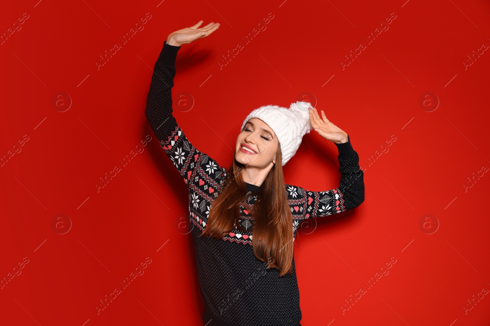 Photo of Young woman wearing Christmas sweater on red background