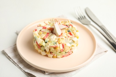 Photo of Delicious salad with fresh crab sticks on white table
