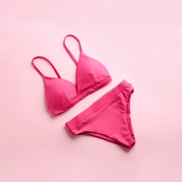 Photo of Beautiful bikini on pink background, top view