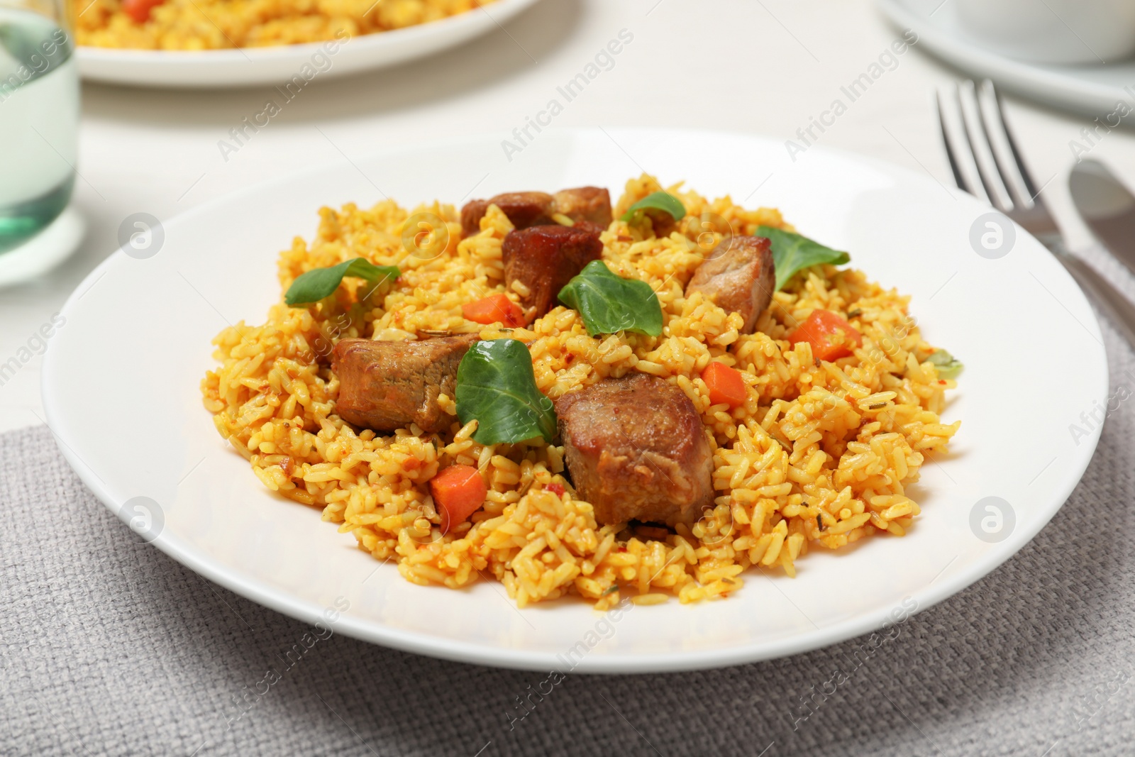 Photo of Plate of delicious rice pilaf with meat on table