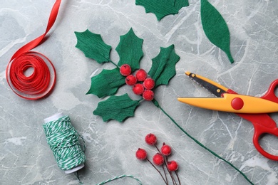 Set of instruments and materials for making mistletoe branch on grey table, flat lay