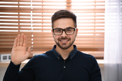 Photo of Happy man using video chat in modern office, view from web camera