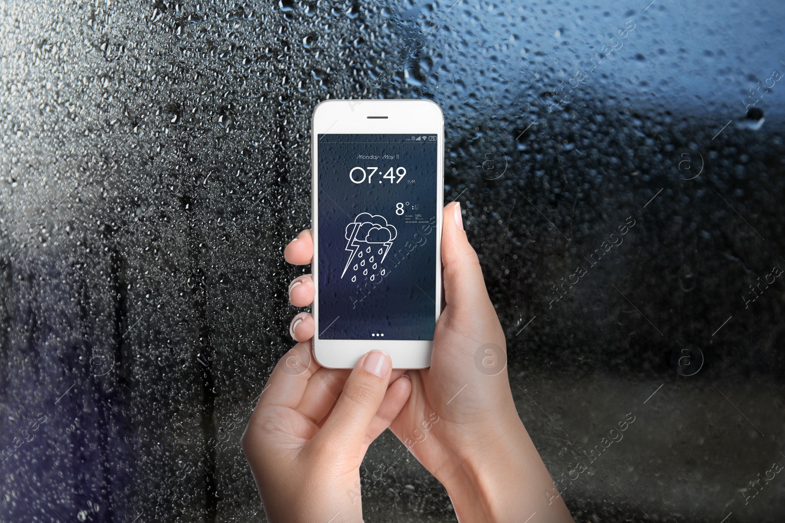 Image of Woman using weather forecast app on smartphone near window indoors, closeup