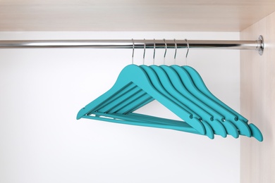 Clothes hangers on metal rail in wardrobe