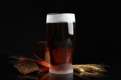 Delicious cold kvass, bread and spikes on black background