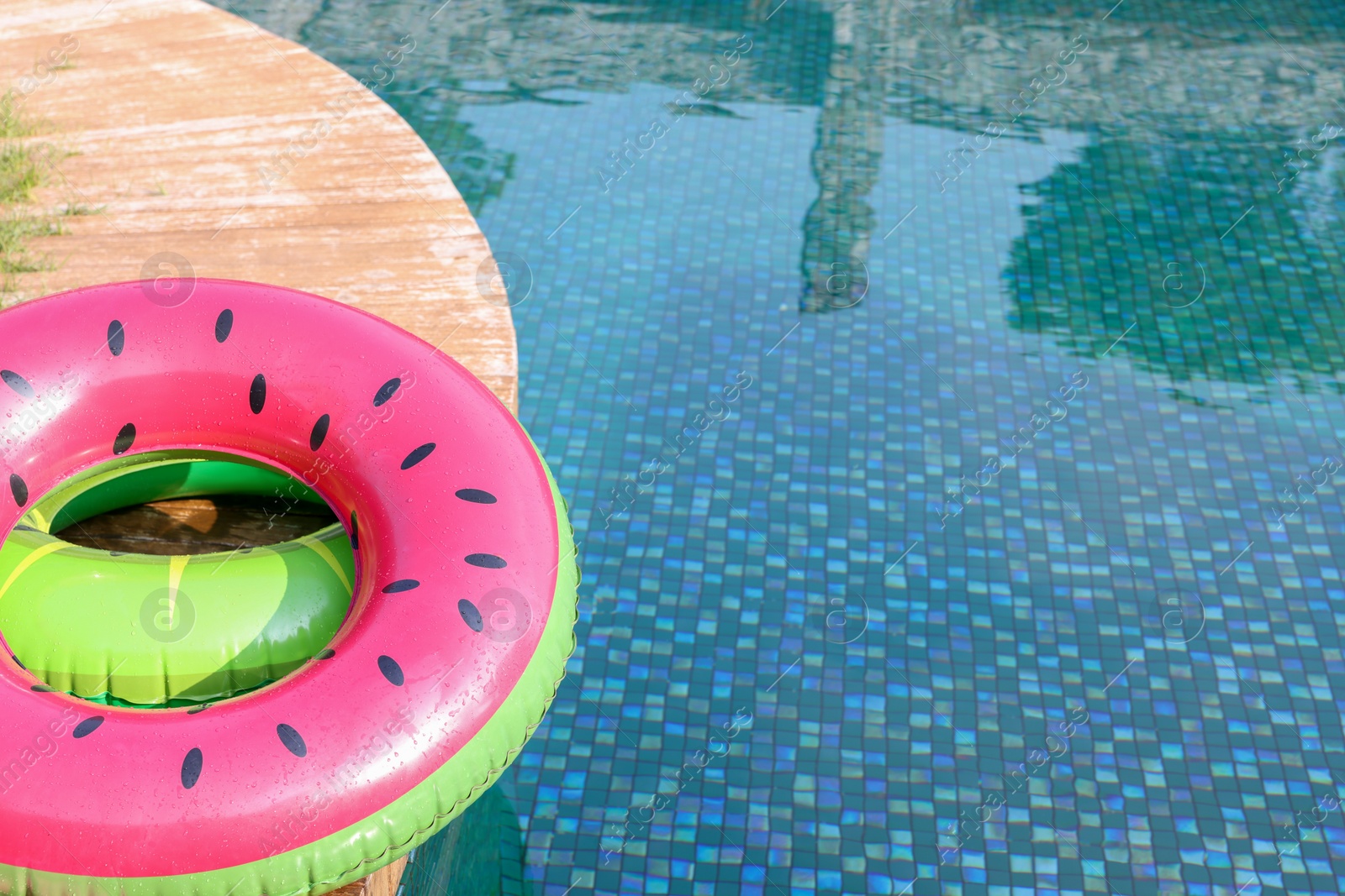 Photo of Inflatable rings on wooden deck near swimming pool. Luxury resort
