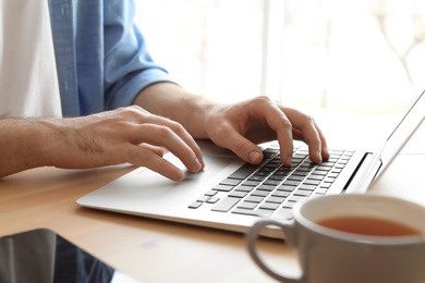 Young man working with laptop at desk. Home office