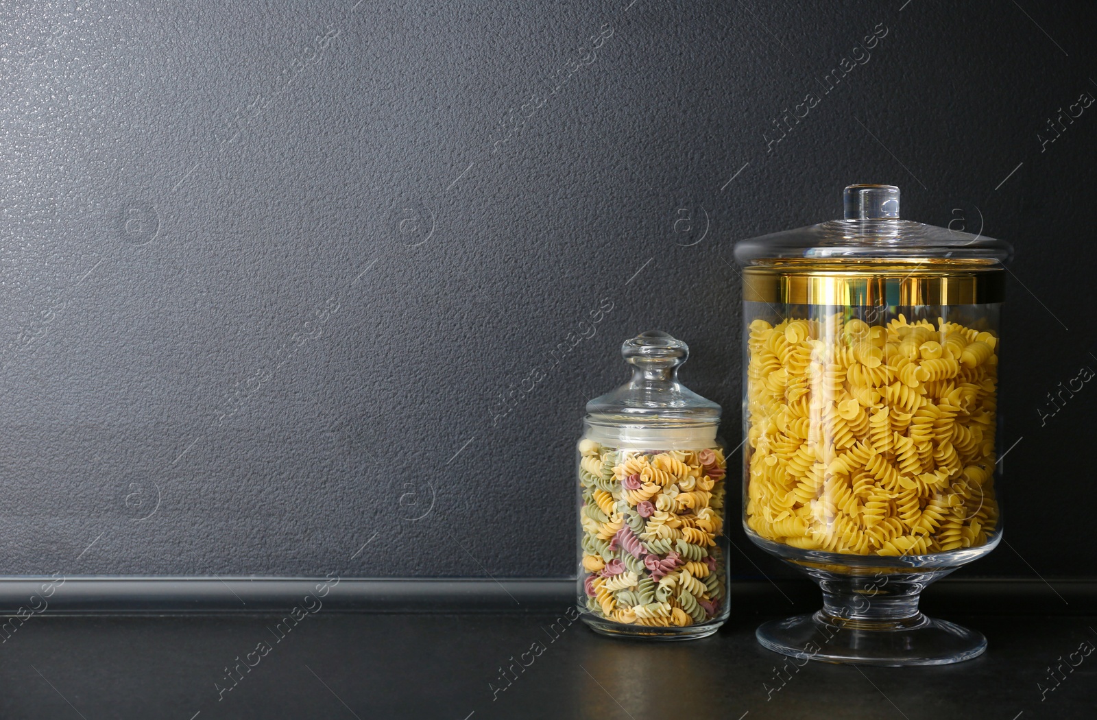 Photo of Products in modern kitchen glass containers on black table. Space for text