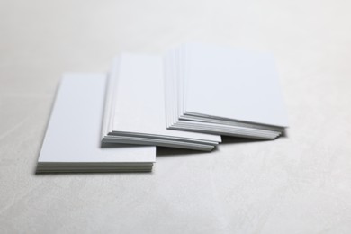 Photo of Blank business cards on light grey textured table, closeup. Mockup for design