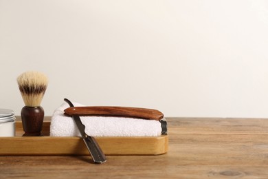 Photo of Set of men's shaving tools on wooden table, space for text