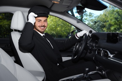 Photo of Young handsome driver in luxury car. Chauffeur service