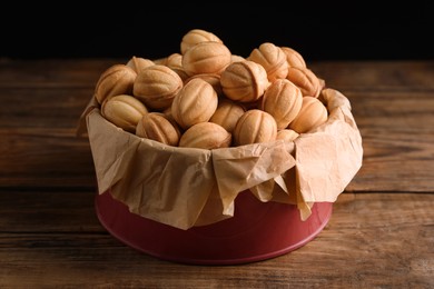 Homemade walnut shaped cookies with boiled condensed milk on wooden table, closeup