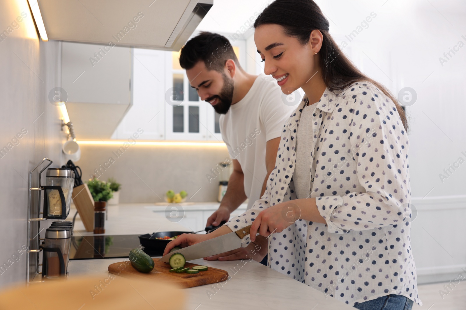 Photo of Happy lovely couple cooking together in kitchen