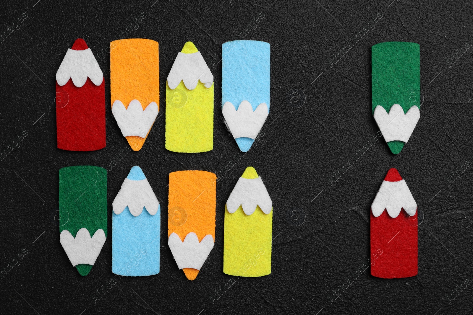 Photo of Flat lay composition with colorful felt pencils on black stone background. Pareto principle concept