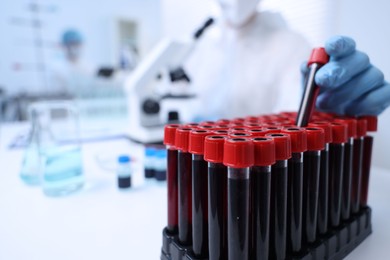 Photo of Scientist working with samples in test tubes in laboratory, closeup