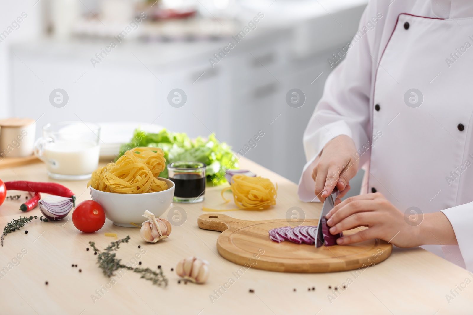 Photo of Female chef cooking food at kitchen table, closeup