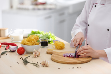 Photo of Female chef cooking food at kitchen table, closeup