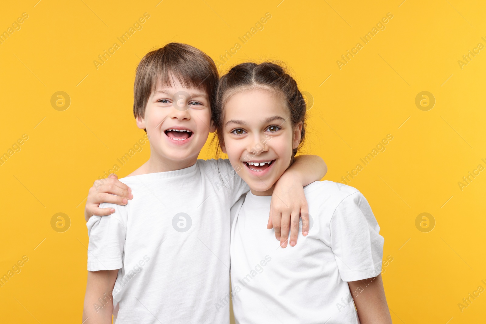 Photo of Happy brother and sister on orange background