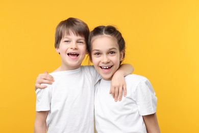 Photo of Happy brother and sister on orange background