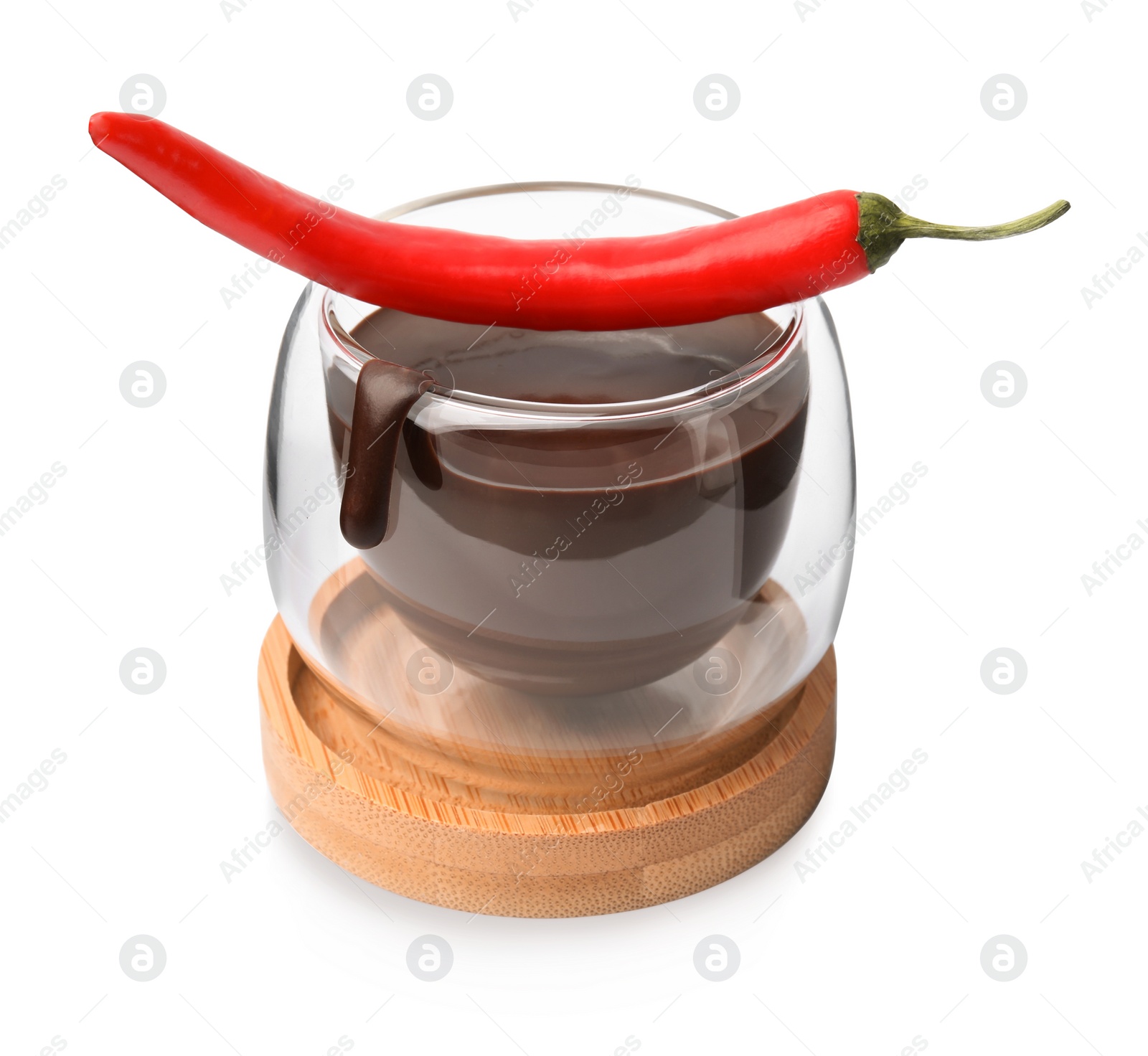 Photo of Glass of hot chocolate with chili pepper on white background