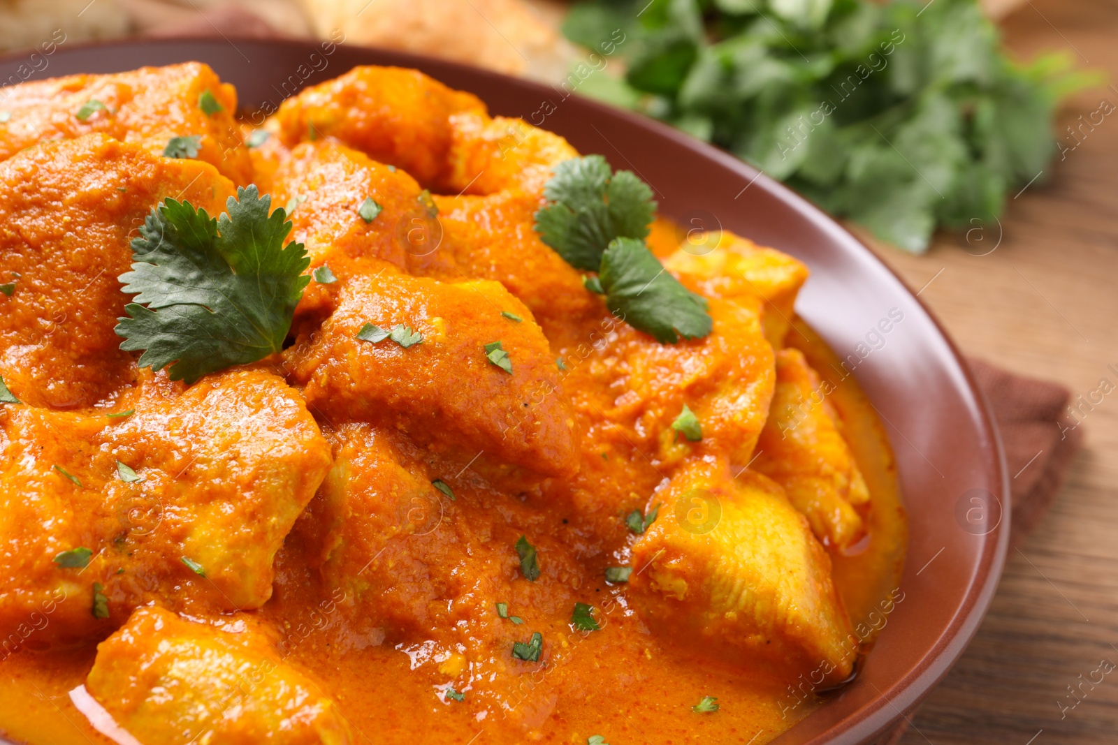 Photo of Bowl of delicious chicken curry on table, closeup