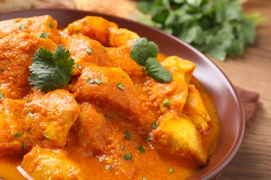 Photo of Bowl of delicious chicken curry on table, closeup