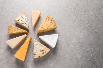 Photo of Flat lay composition with different kinds of cheese on grey background, space for text