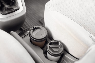 Coffee to go. Paper cups with tasty drink in holder inside of car