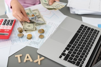 Photo of Young female calculating taxes at table, closeup