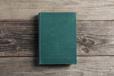 Old hardcover book on grey wooden table, top view