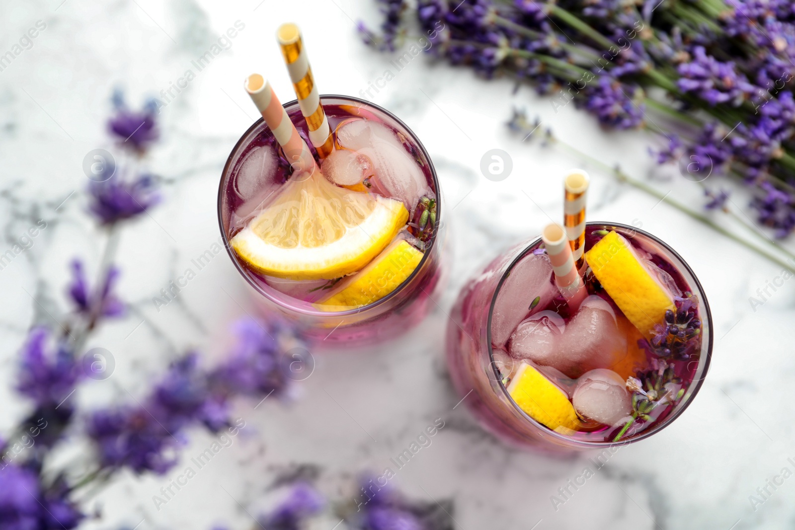 Photo of Fresh delicious lemonade with lavender and straws on white marble table, top view